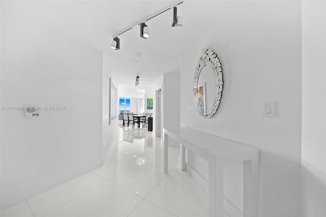 hallway featuring light tile patterned flooring and track lighting