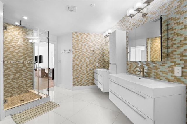 bathroom with tasteful backsplash, tile patterned floors, vanity, tile walls, and a shower with shower door