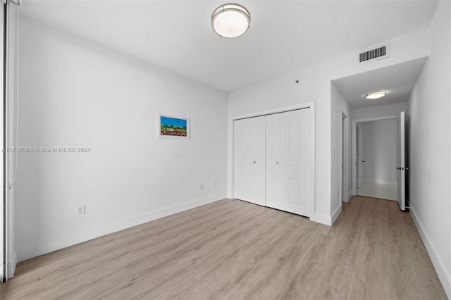 unfurnished bedroom with light hardwood / wood-style floors and a closet