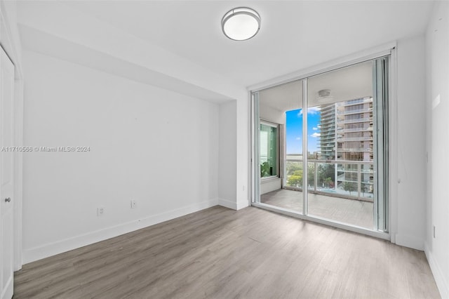 unfurnished room featuring hardwood / wood-style flooring and a wall of windows