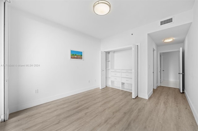 unfurnished bedroom featuring a closet and light hardwood / wood-style flooring