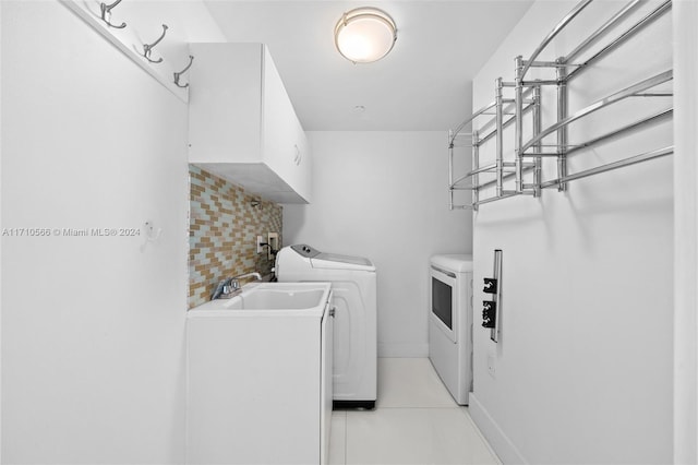 washroom featuring cabinets and washing machine and dryer