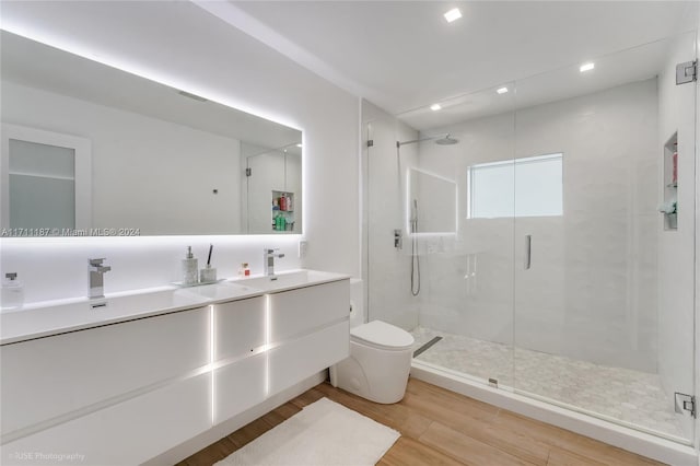 bathroom with hardwood / wood-style floors, toilet, an enclosed shower, and vanity