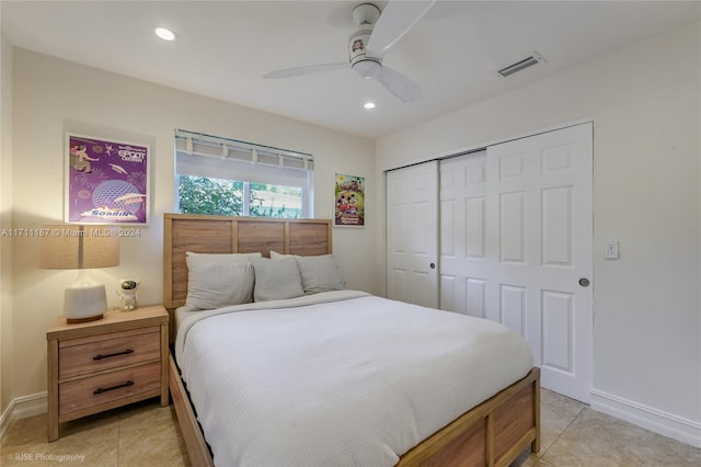 tiled bedroom with ceiling fan and a closet