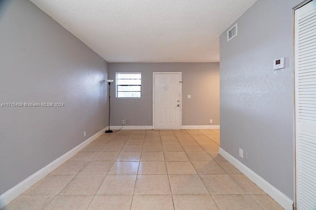 tiled entrance foyer with a textured ceiling