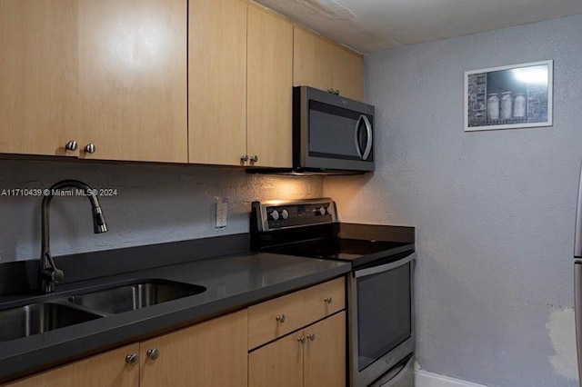 kitchen featuring sink, light brown cabinets, and appliances with stainless steel finishes