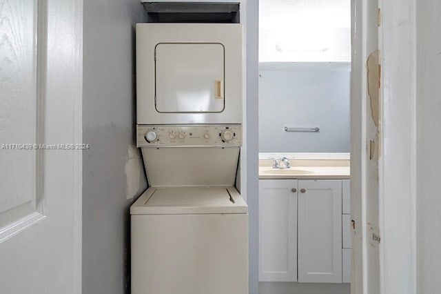 washroom featuring stacked washer / drying machine and sink