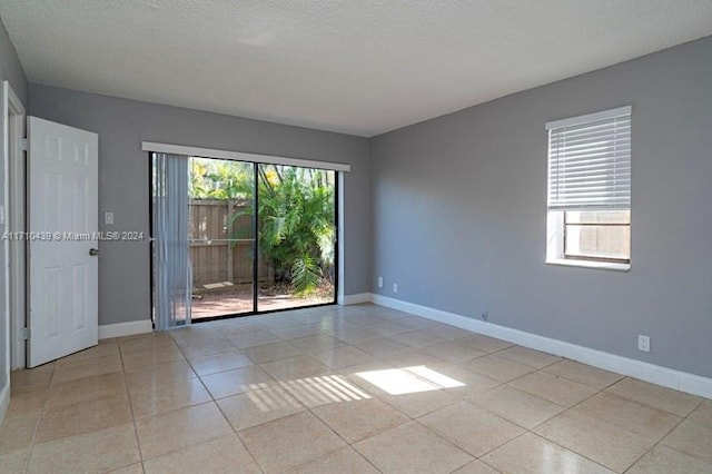 tiled spare room with a textured ceiling