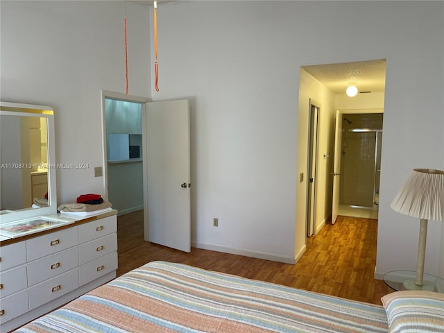 bedroom featuring light hardwood / wood-style flooring and a textured ceiling