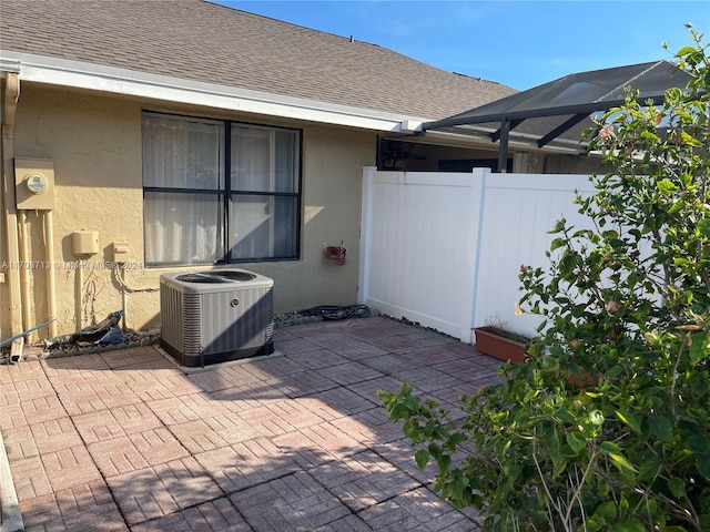 view of patio featuring a lanai and central air condition unit