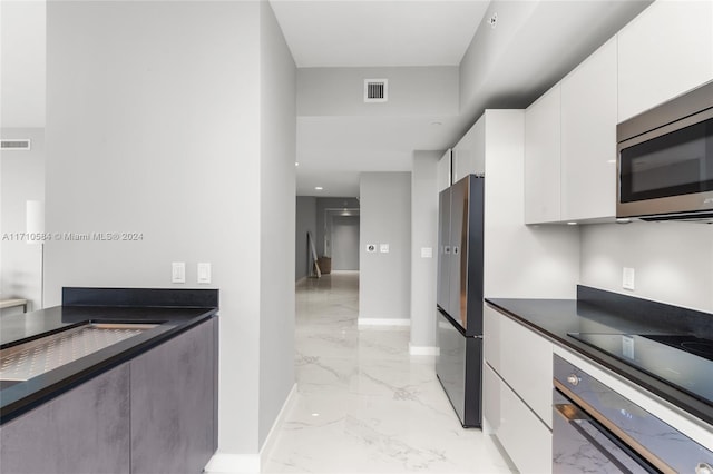 kitchen featuring white cabinetry and appliances with stainless steel finishes