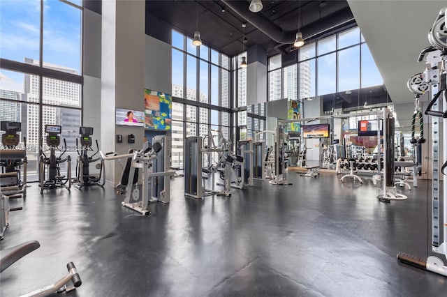 exercise room with ceiling fan and a towering ceiling