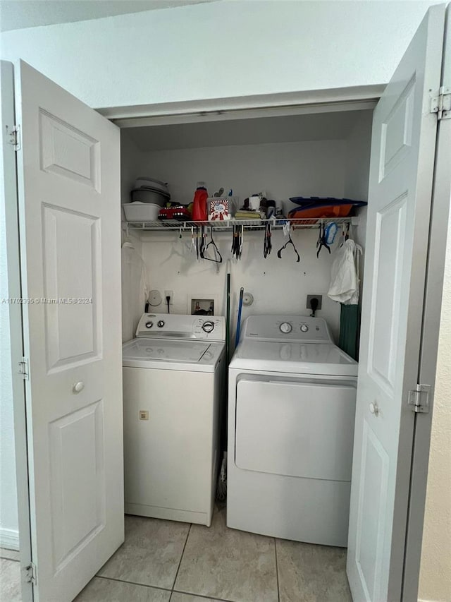 laundry room with washer and dryer and light tile patterned floors