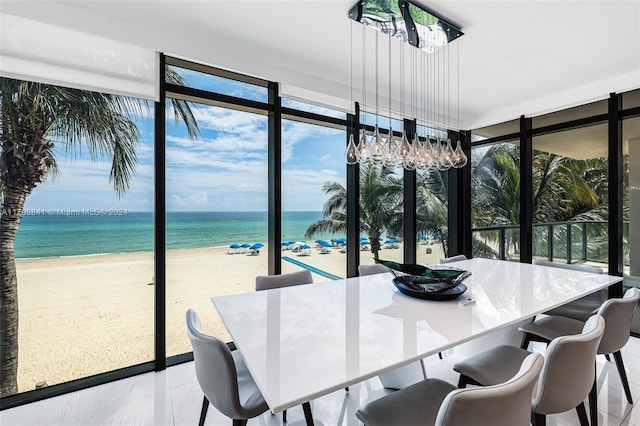 tiled dining space featuring a beach view and a water view