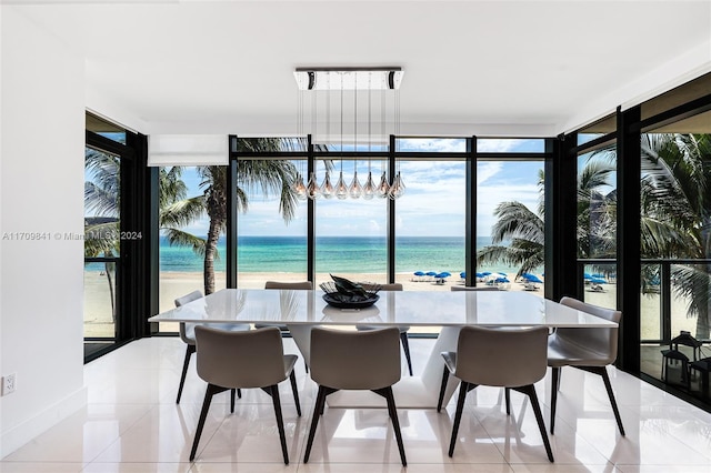 dining area featuring plenty of natural light, a water view, and a beach view