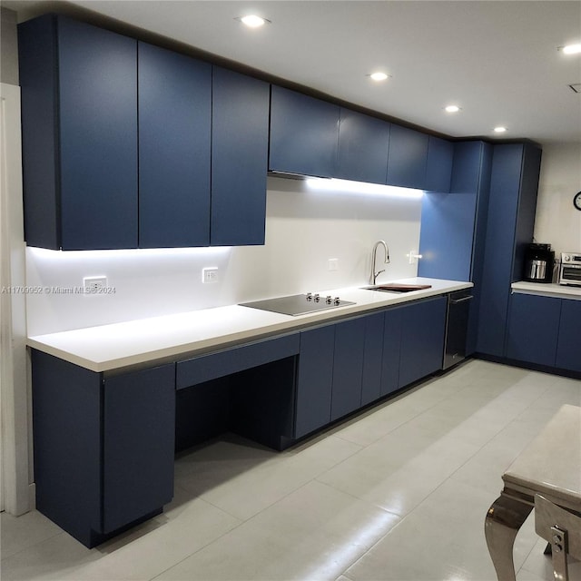 kitchen with black electric stovetop and blue cabinets