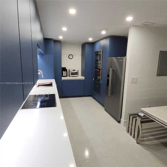 kitchen with sink, blue cabinets, and appliances with stainless steel finishes