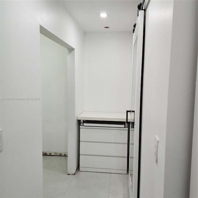 interior space with light tile patterned floors and a barn door