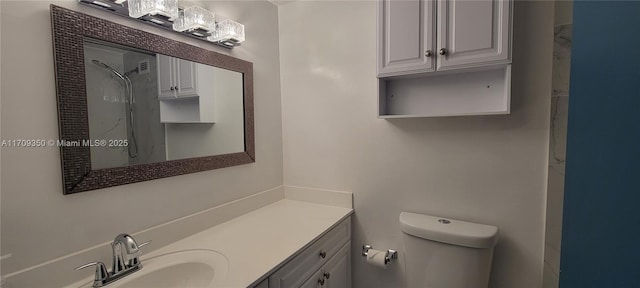 bathroom with toilet, vanity, and walk in shower