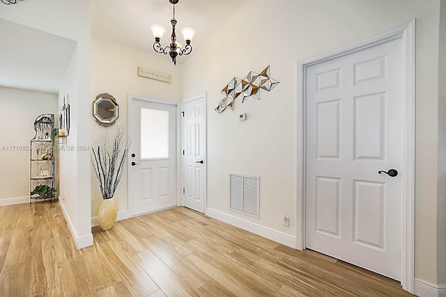 foyer entrance with a notable chandelier and wood-type flooring