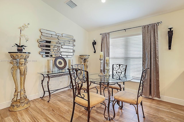 dining space with lofted ceiling, plenty of natural light, and light wood-type flooring