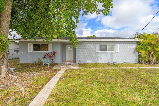 ranch-style home featuring a front lawn