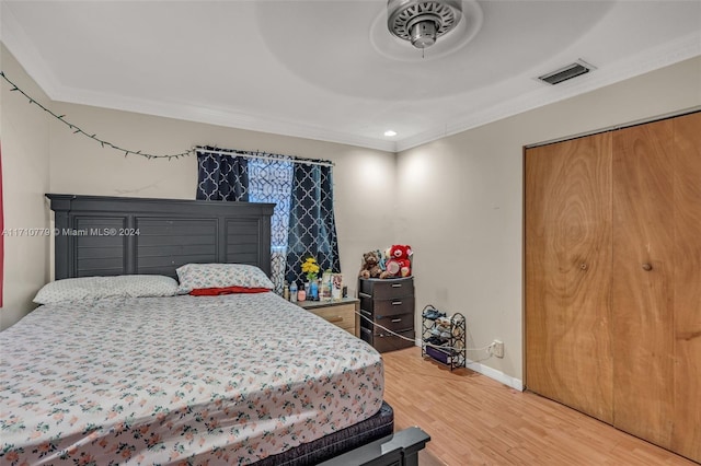 bedroom with ceiling fan, hardwood / wood-style floors, and ornamental molding