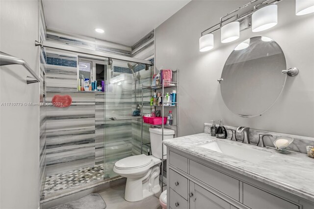 bathroom with vanity, toilet, and a shower with door