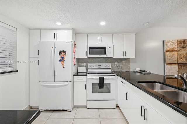 kitchen with white cabinetry, sink, a textured ceiling, white appliances, and light tile patterned flooring