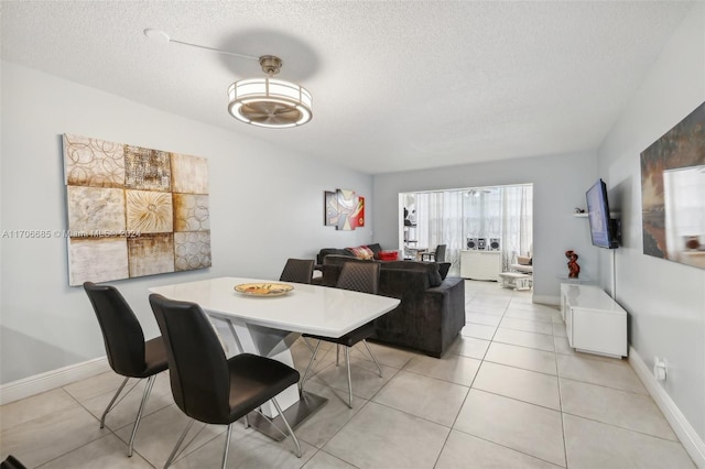 tiled dining room featuring a textured ceiling