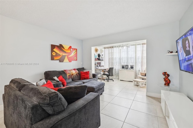 living room with a textured ceiling and light tile patterned flooring