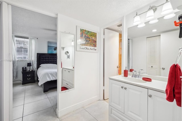 bathroom featuring tile patterned flooring, vanity, and a textured ceiling