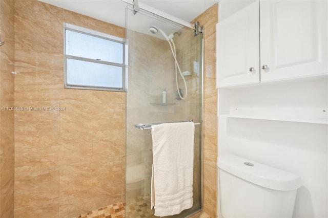 bathroom with tiled shower and toilet