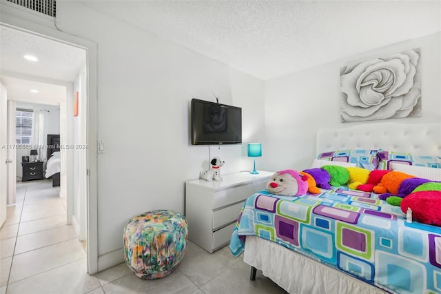 bedroom featuring light tile patterned floors and a textured ceiling