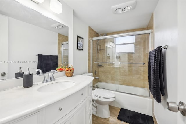 full bathroom with vanity, bath / shower combo with glass door, and toilet