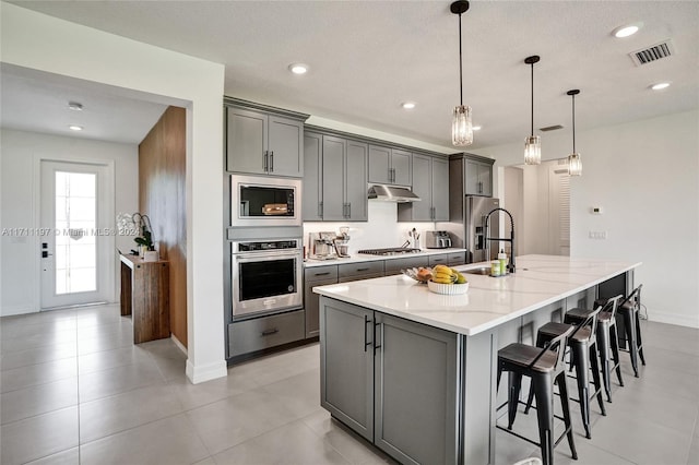 4536 N Silverwood Ln N, Oakland Park, FL 33309 - kitchen featuring visible vents, appliances with stainless steel finishes, under cabinet range hood, a sink, and gray cabinetry