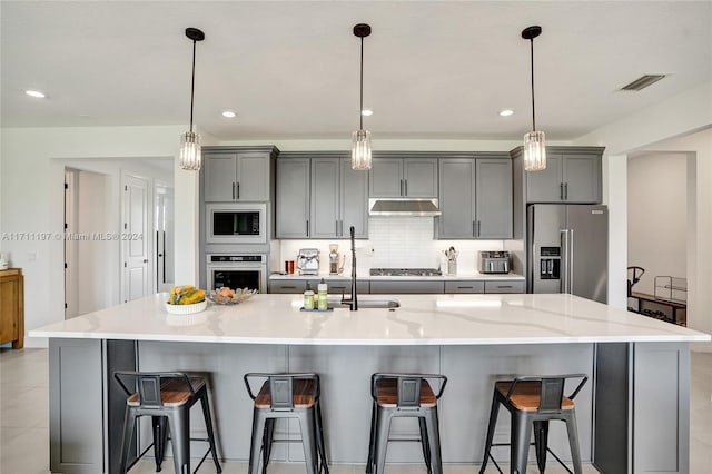 4536 N Silverwood Ln N, Oakland Park, FL 33309 - kitchen with gray cabinets, backsplash, under cabinet range hood, stainless steel appliances, and visible vents