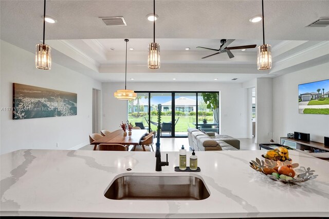 4536 N Silverwood Ln N, Oakland Park, FL 33309 - kitchen with visible vents, crown molding, a raised ceiling, open floor plan, and pendant lighting
