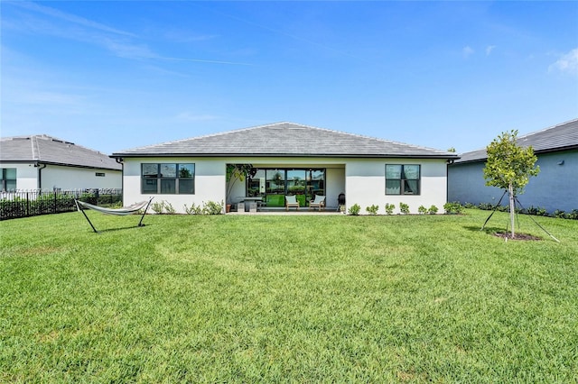 4536 N Silverwood Ln N, Oakland Park, FL 33309 - back of property featuring a patio area, a lawn, stucco siding, and fence