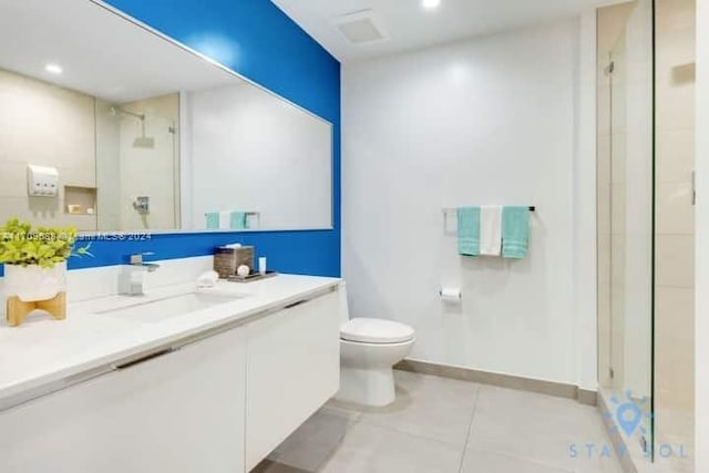 bathroom with tile patterned flooring, vanity, toilet, and walk in shower