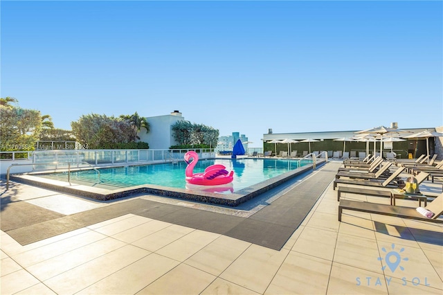 view of swimming pool featuring a patio area and a water view