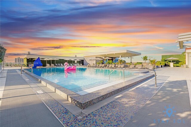 pool at dusk with a patio