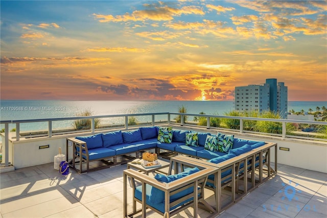 patio terrace at dusk featuring an outdoor living space and a water view