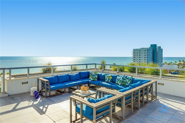 view of patio / terrace with an outdoor living space, a water view, a beach view, and a balcony