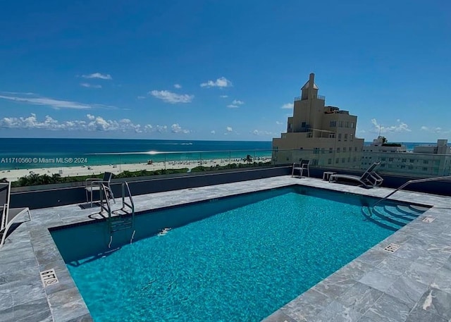 view of pool with a water view and a patio