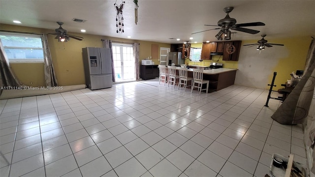 kitchen with a breakfast bar, light tile patterned floors, and stainless steel appliances