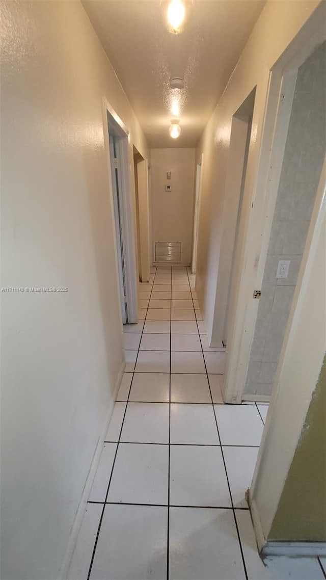 hallway with light tile patterned floors and a textured ceiling