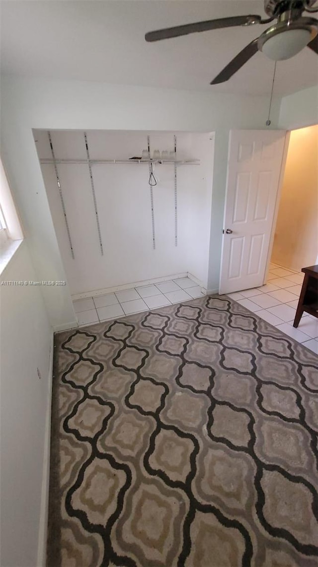 unfurnished bedroom with light tile patterned floors, a closet, and ceiling fan