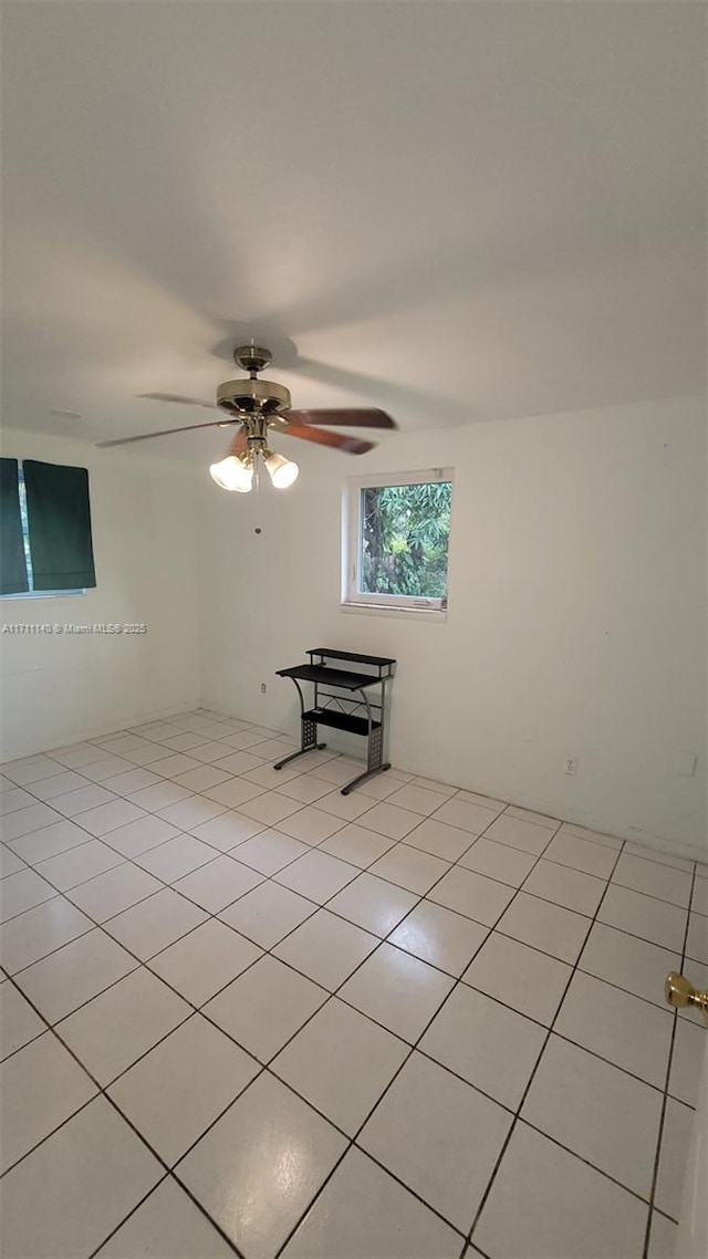 tiled empty room featuring ceiling fan