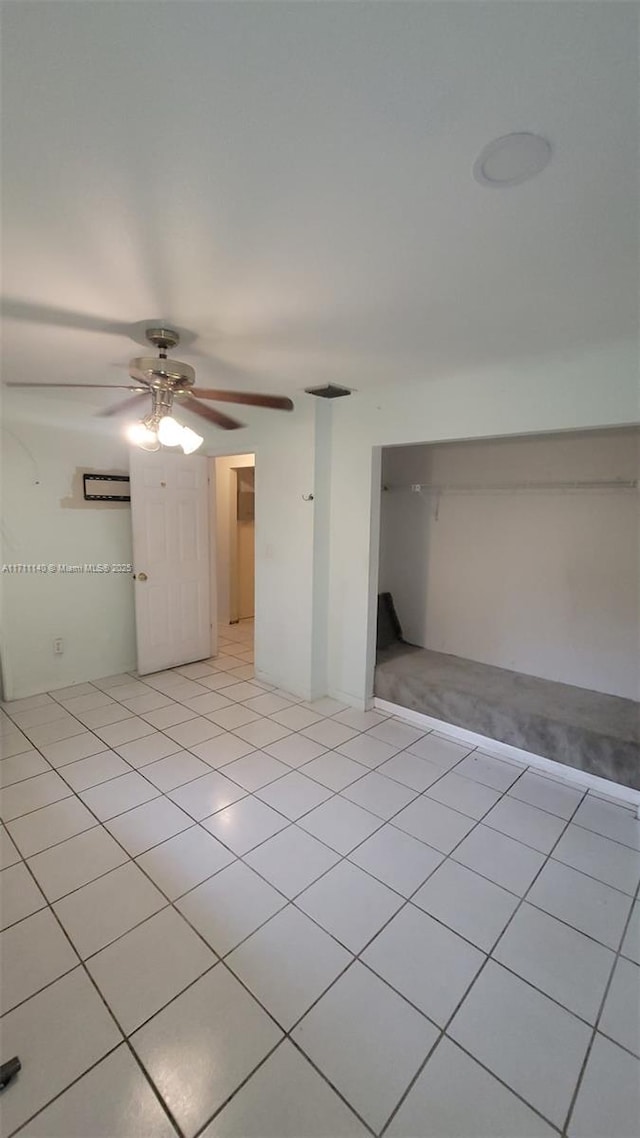 tiled spare room featuring ceiling fan